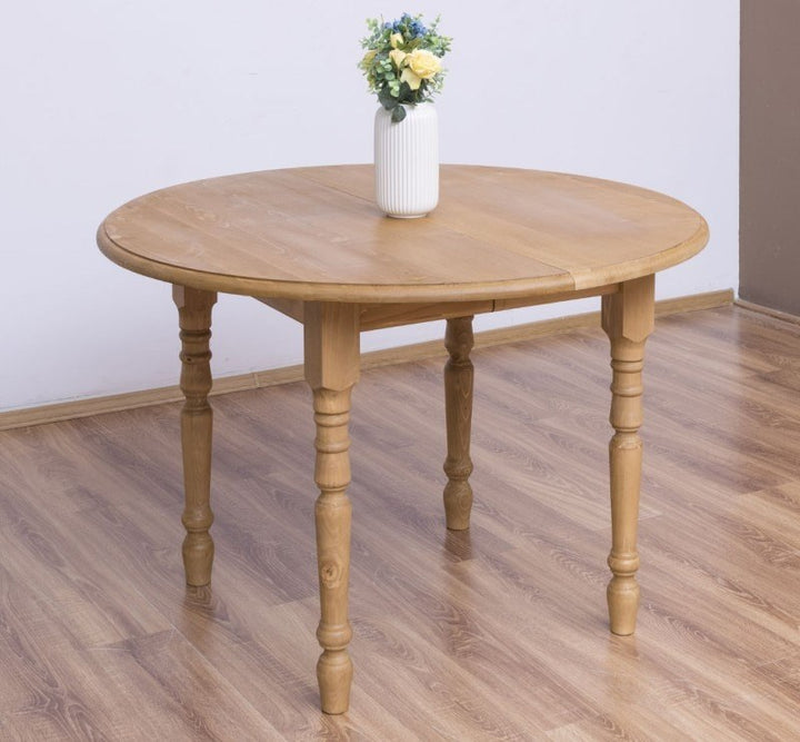 Table ronde extensible en pin massif avec plateau en pin, vue trois-quarts