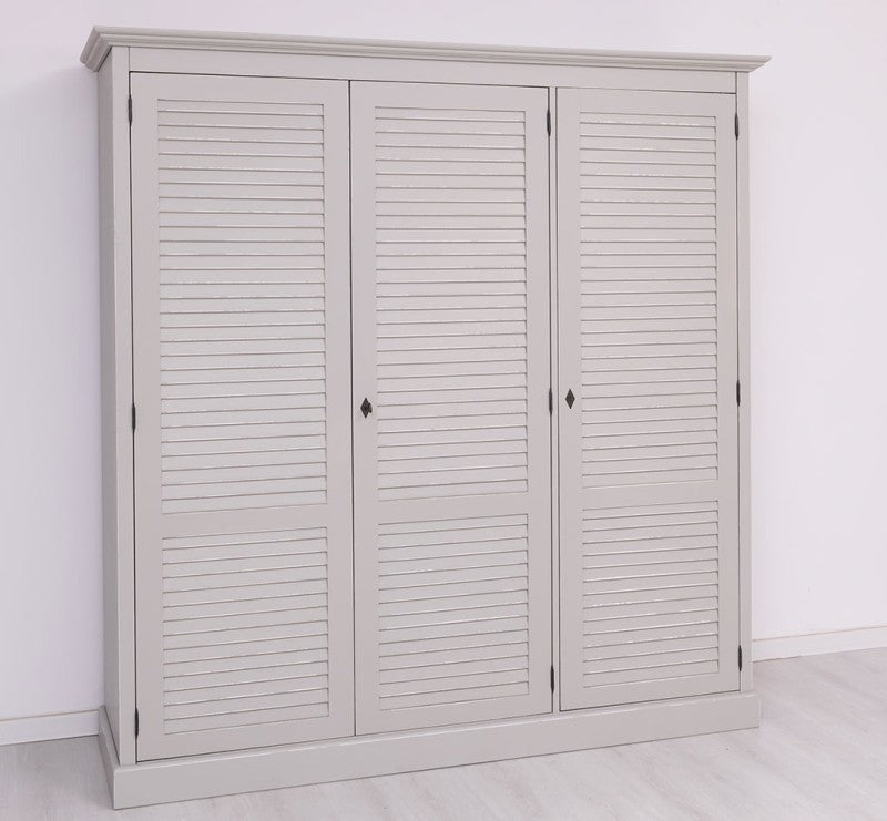 Armoire en pin massif à trois portes persiennes, vue de trois quarts