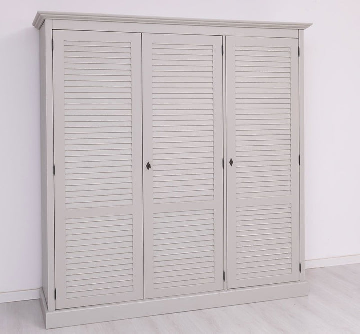 Armoire en pin massif à trois portes persiennes, vue de trois quarts