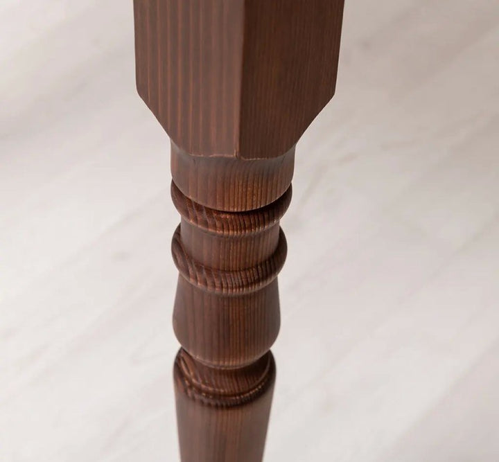 Détail d’un pied tourné en pin massif de la table ronde extensible