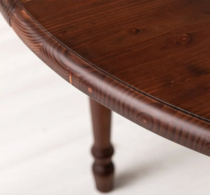 Détail du bord du plateau et du pied de la table ronde extensible en pin massif