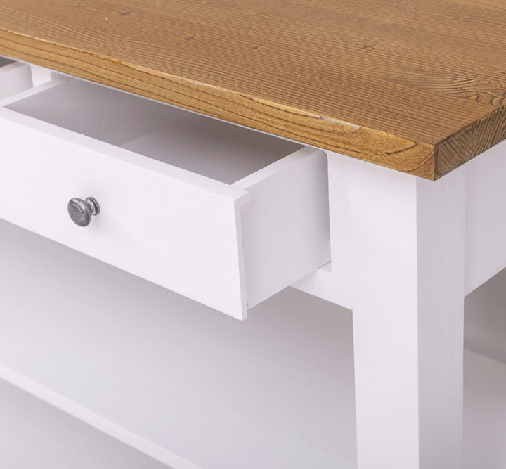 Détail d’un tiroir ouvert sur meuble bas de cuisine en pin massif avec structure blanche et plateau bois naturel.