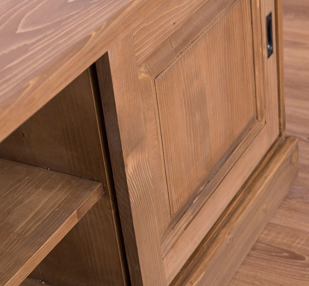 Détail d’une porte coulissante du meuble TV en pin massif finition bois naturel.  

