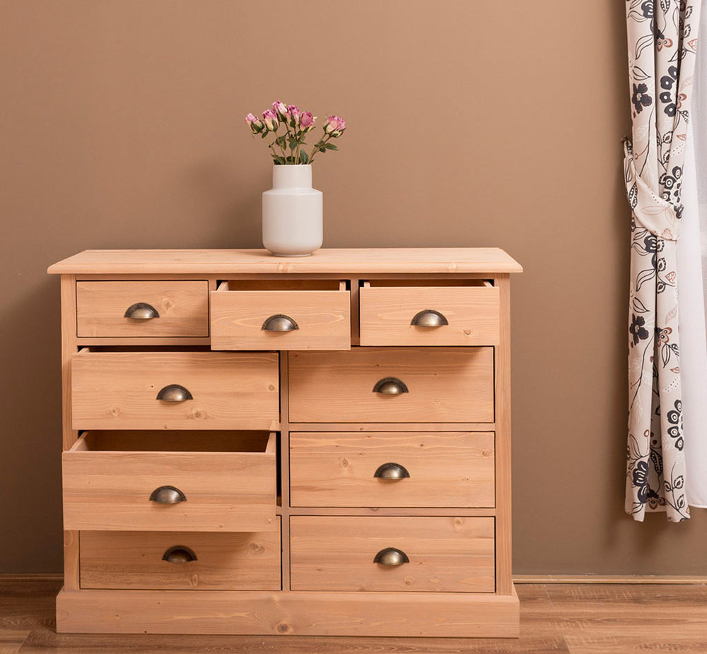 Commode en pin massif avec 9 tiroirs ouverts, 122 cm de largeur.
