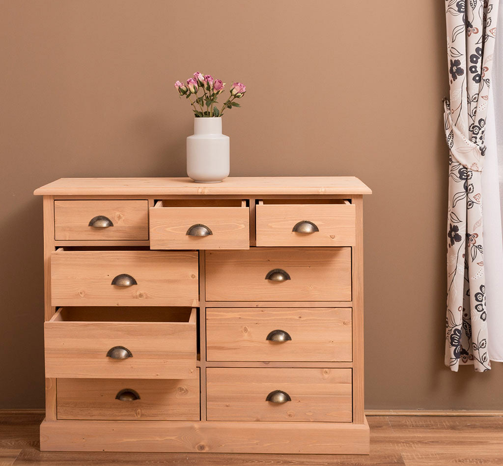 Commode en pin massif avec 9 tiroirs ouverts, 122 cm de largeur.