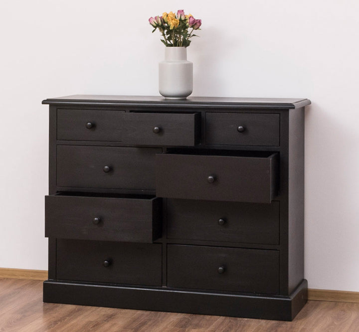 Commode en pin massif avec 9 tiroirs finition sombre, 122 cm de largeur.