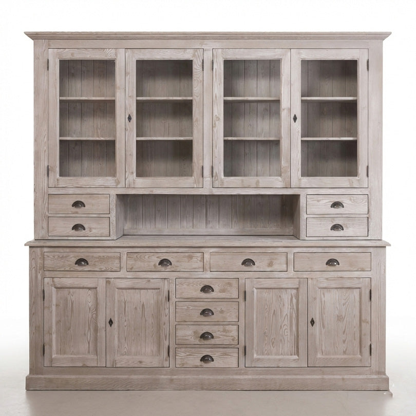 Grand vaisselier en pin massif avec quatre portes vitrées en partie haute, niche centrale ouverte, tiroirs latéraux, rangée de tiroirs et portes pleines de rangement en partie basse.