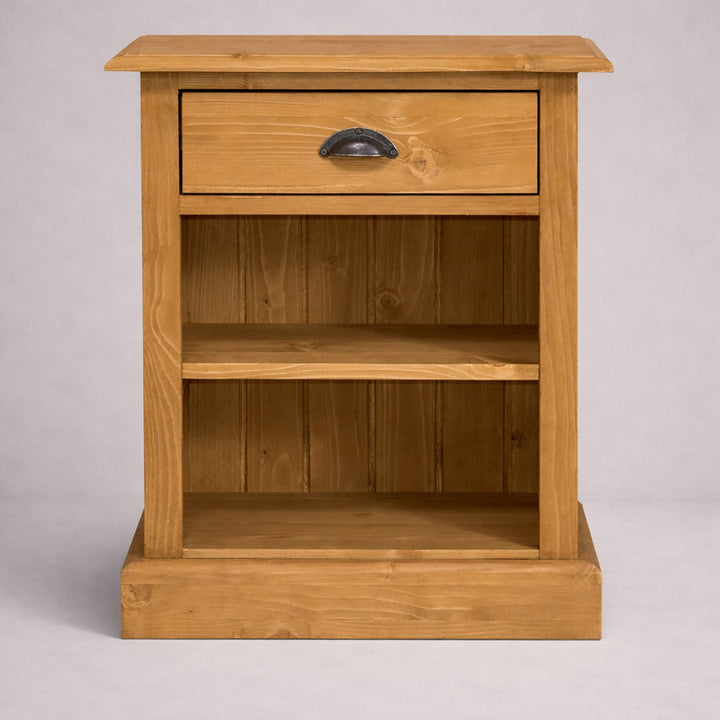 Table de chevet en pin massif avec tiroir et étagères ouvertes, vue frontale sur fond gris.