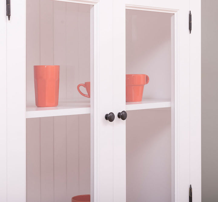 Détail des poignées d’un meuble colonne de cuisine avec vitrine