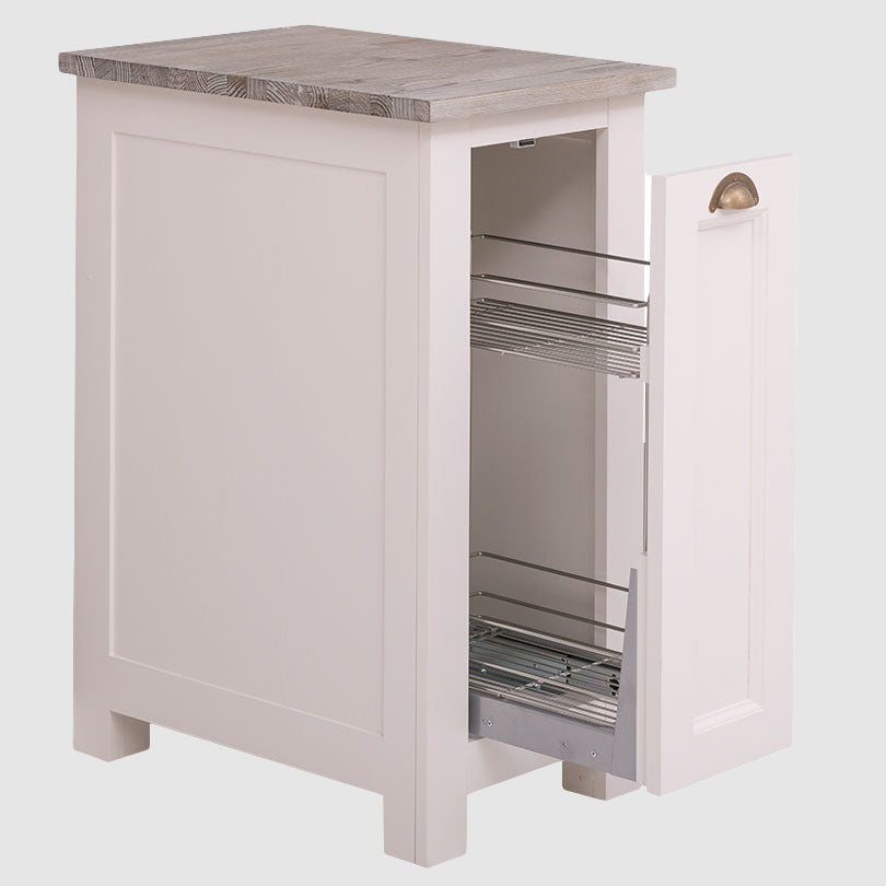 Vue d'un meuble bas de cuisine blanc ouvert révélant un système de rangement coulissant bicolore avec deux paniers en métal pour bouteilles.