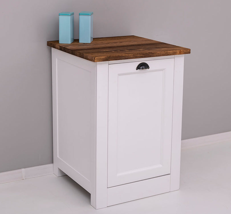 Habillage de lave-vaisselle blanc et bois foncé mis en situation contre un mur gris, décoré de deux boîtes de conservation bleues sur le plateau.