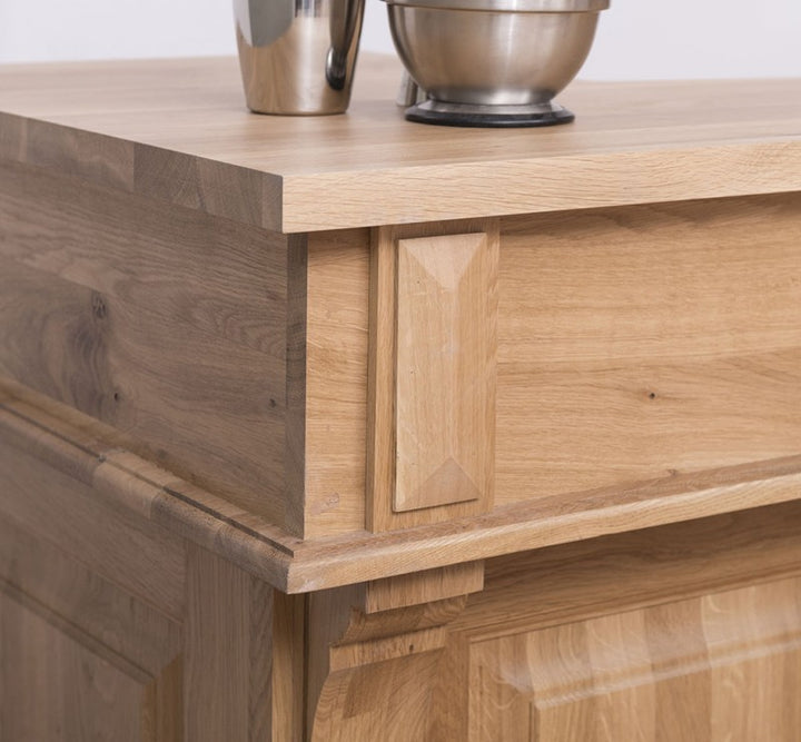 Détail du montant vertical et du chant du plateau d’un bar en chêne, mettant en évidence les moulures et arêtes