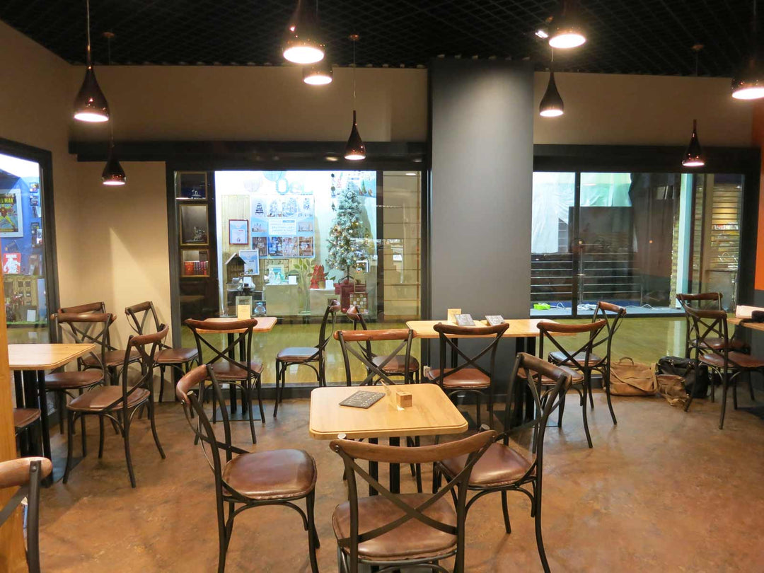 Aménagement de restaurant gastronomique avec tables en bois et chaises bistrot