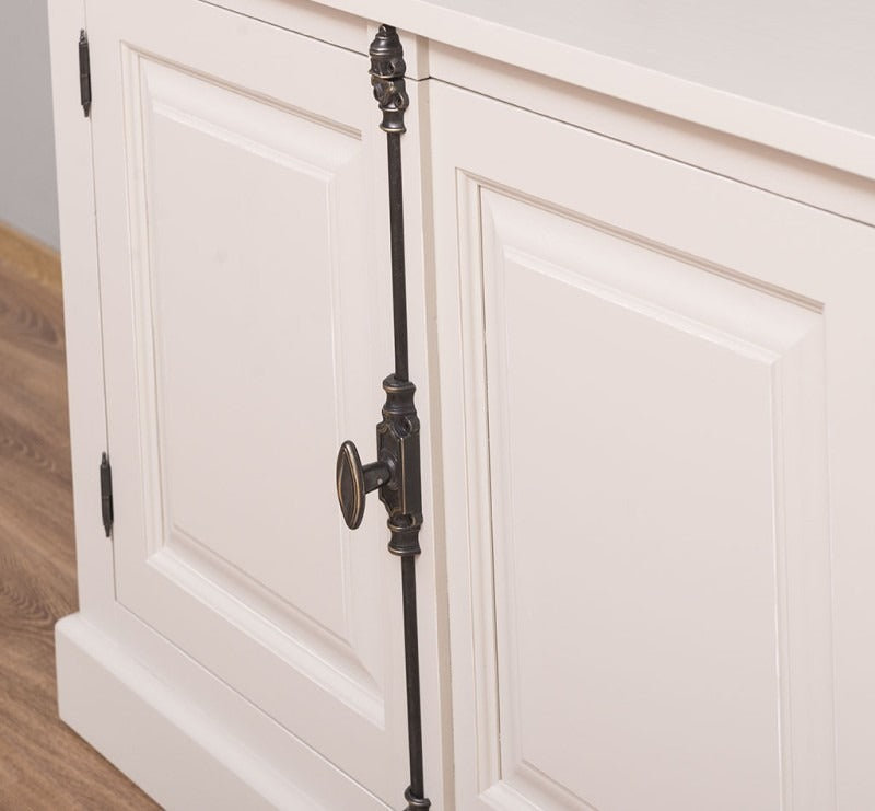Détail de la crémone métallique décorative sur une porte du buffet en pin massif