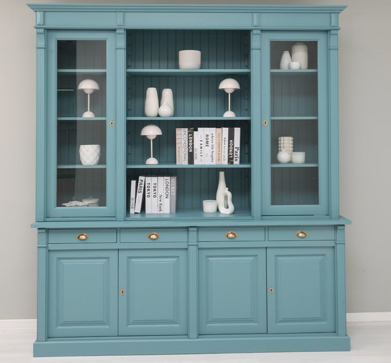 Vue frontale d’une bibliothèque en pin massif style Directoire bleue avec étagères ouvertes et portes vitrées latérales