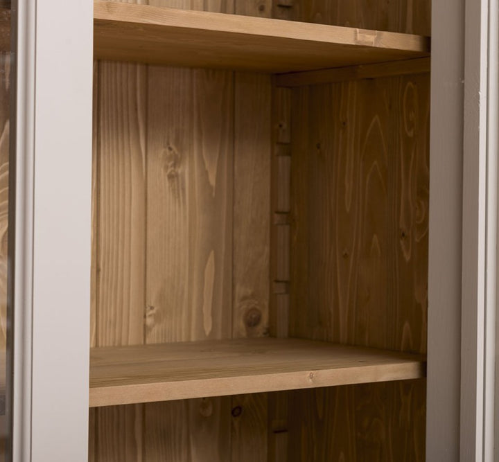 Détail des étagères en bois naturel à l’intérieur d’une bibliothèque en pin massif style Directoire