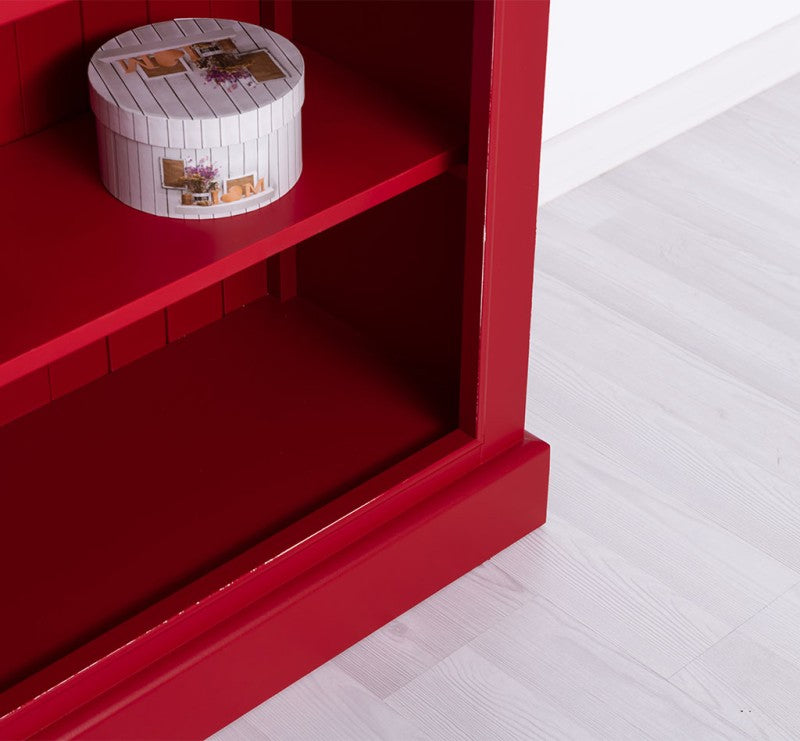 Détail intérieur d’une bibliothèque basse en pin massif peint rouge