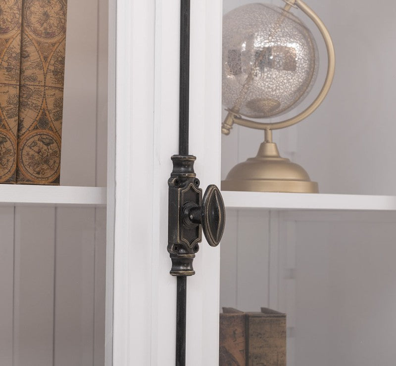 Détail de la crémone métallique sur une porte vitrée de vitrine en pin massif