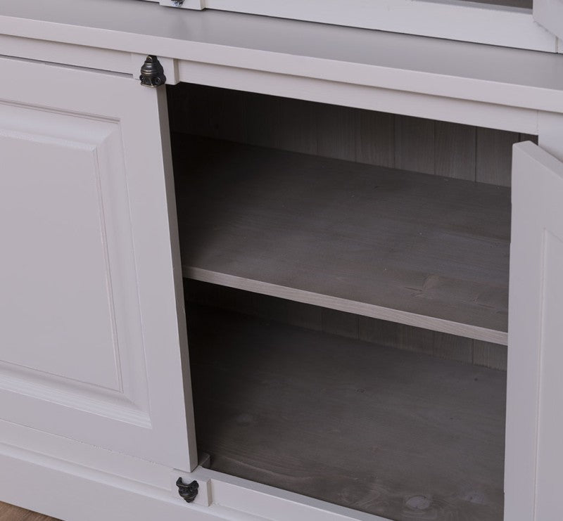 Intérieur de la partie basse d’une vitrine en pin massif avec portes pleines et étagères