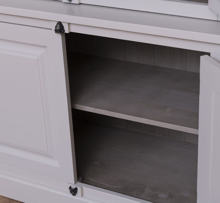 Intérieur de la partie basse d’une vitrine en pin massif avec portes pleines et étagères