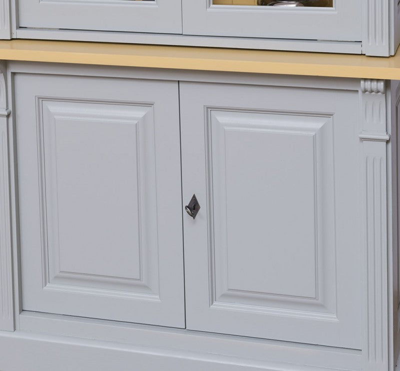 Détail des portes basses moulurées fermées d’une bibliothèque en pin massif style Directoire gris clair