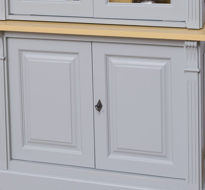 Détail des portes basses moulurées fermées d’une bibliothèque en pin massif style Directoire gris clair