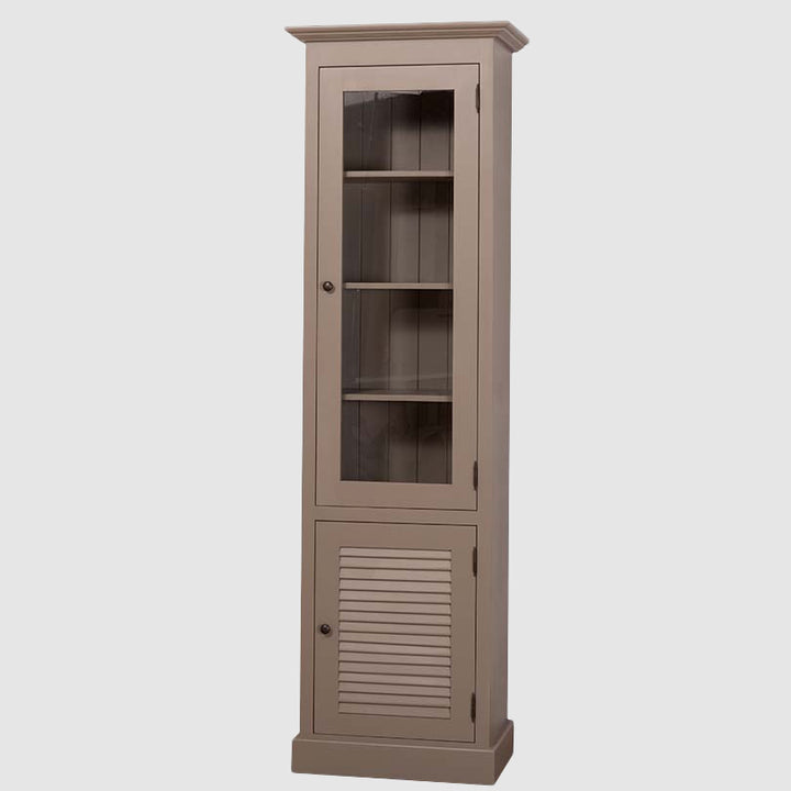 Vitrine colonne étroite en bois peint de teinte taupe, avec une porte vitrée en partie haute laissant voir des étagères intérieures et une porte pleine à lames horizontales en partie basse, présentée sur fond neutre.