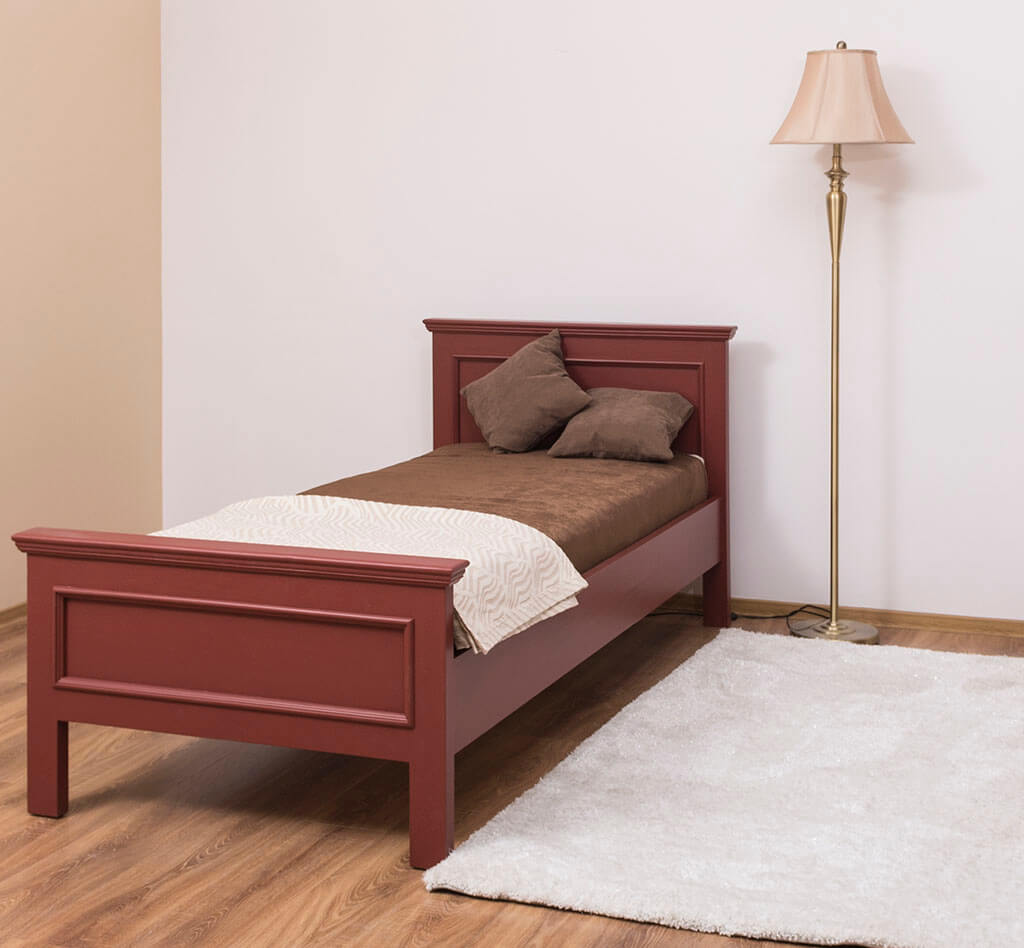Lit en pin massif dans une chambre avec lampe et tapis — Le Grenier Campagnard