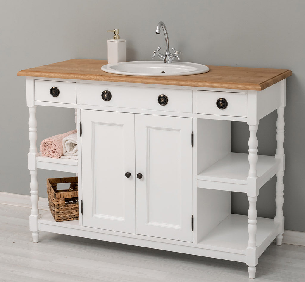 Meuble de salle de bain blanc avec plateau en chêne massif et poignées anciennes en laiton.