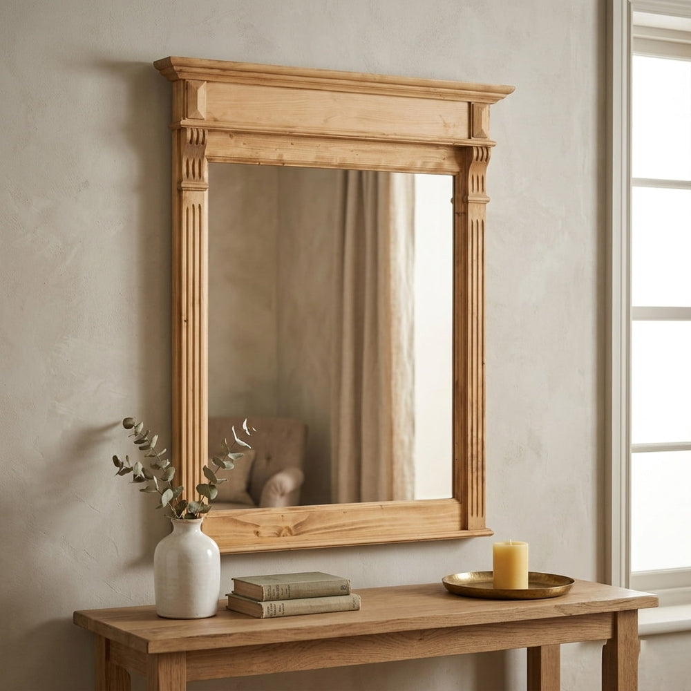 Miroir rectangulaire en bois clair avec cadre sculpté de style Louis-Philippe suspendu au-dessus d'une console en bois dans un intérieur rustique chic.